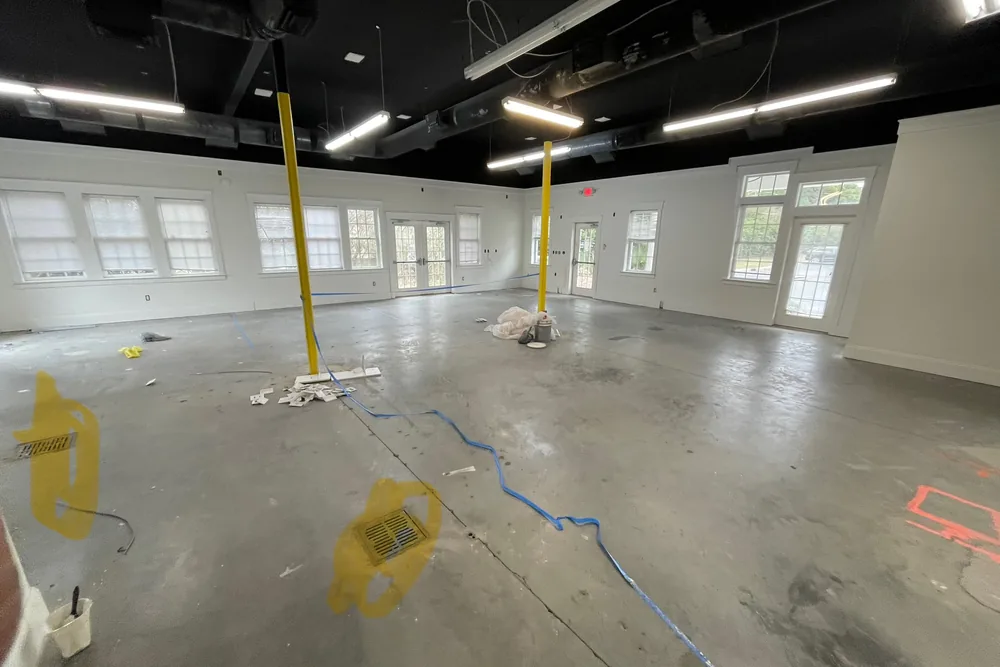 Before: commercial space stripped to the concrete slab with temporary supports at the start of a make-ready.