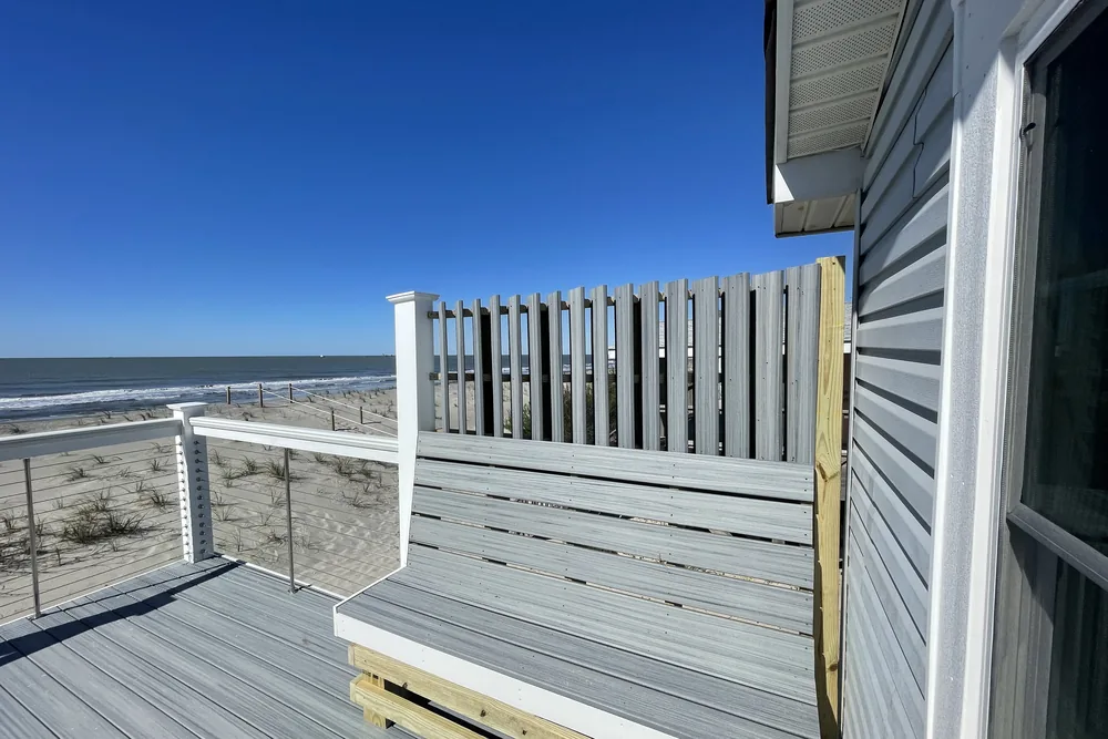 Built-in bench and privacy screen on the oceanfront deck extension in Oak Island, with cable railing.