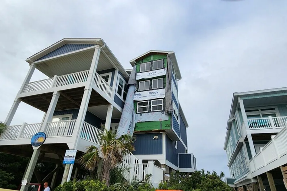 Rebuilt wall section in Oak Island, sheathed and wrapped and ready for siding, on a three-story coastal home.